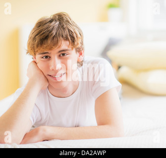 Teenage boy (14-15) lying on bed, Looking at camera Banque D'Images