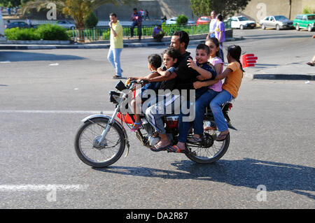 Un fathr et ses cinq enfants conduire une motocyclette d'une manifestation contre le président égyptien Morsi à la place Tahrir au Caire, Égypte, 30 juin 2013. Le président égyptien Morsi célèbre une année en poste le 30 juin 2013 au milieu des manifestations contre son gouvernement islamiste. Photo : MATTHIAS TOEDT Banque D'Images