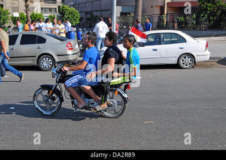 Trois jeunes hommes la moto à une manifestation contre le président égyptien Morsi à la place Tahrir au Caire, Égypte, 30 juin 2013. Le président égyptien Morsi célèbre une année en poste le 30 juin 2013 au milieu des manifestations contre son gouvernement islamiste. Photo : MATTHIAS TOEDT Banque D'Images