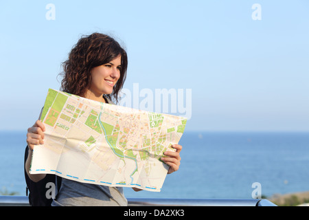 Belle femme touriste en vacances avec une carte de la ville avec la mer et le ciel en arrière-plan Banque D'Images