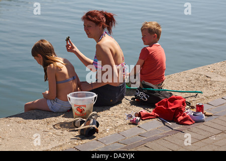 Femme, garçon et fille en crabe à Poole Harbour en Juin Banque D'Images