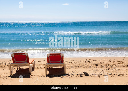 Deux chaises longues sur la plage par la mer Banque D'Images