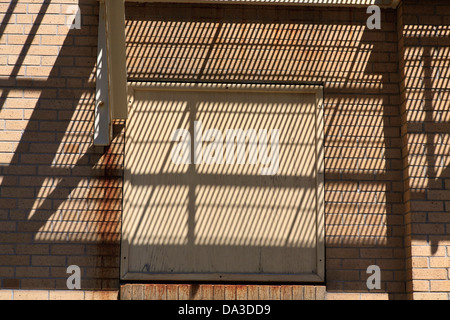 Ombres sur un mur de brique d'une issue de secours Banque D'Images