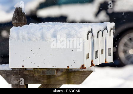 Boîtes aux lettres sur une route de campagne couverte de neige fraîchement tombée. Banque D'Images