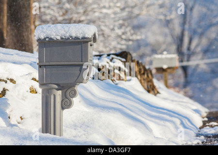 Boîtes aux lettres sur une route de campagne couverte de neige fraîchement tombée. Banque D'Images