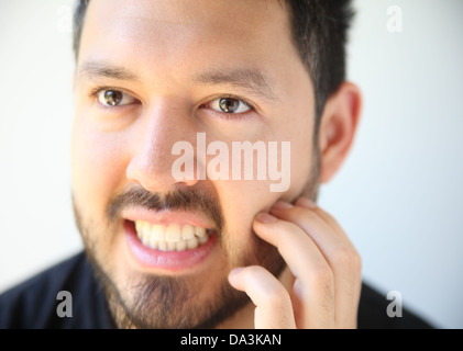 Jeune homme rayures ses cheveux du visage Banque D'Images