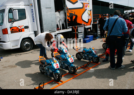 Une mère aide son fils avant le début des courses de mini-motos pour les enfants de la concurrence à Palma de Majorque, Espagne Banque D'Images