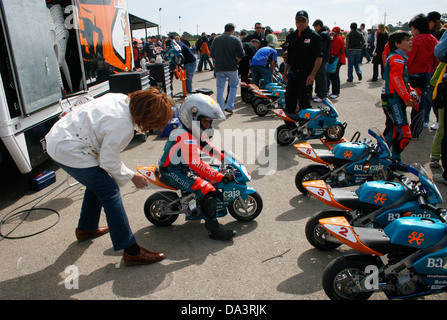 Une mère aide son fils avant le début des courses de mini-motos pour les enfants de la concurrence à Palma de Majorque, Espagne Banque D'Images