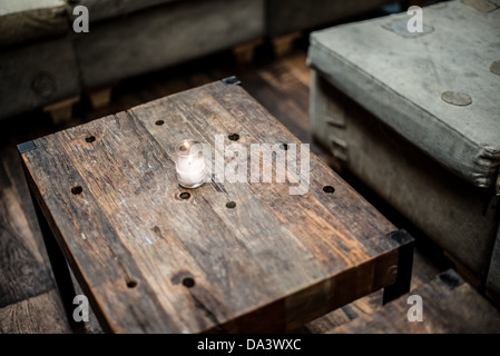 Une petite bougie votive ssits sur une table en bois rustique dans un restaurant bar. Banque D'Images