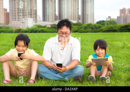 Happy Family using smart phone et Pc tablette piscine Banque D'Images