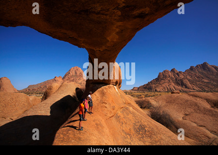 En vertu de la famille rocher naturel arche à Spitzkoppe (à gauche), et Pondok Montagnes en distance (à droite), la Namibie, l'Afrique Banque D'Images