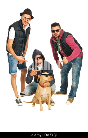 Groupe funky de trois rappeurs soulignant leur pitbull dog avec des lunettes de soleil isolé sur fond blanc Banque D'Images