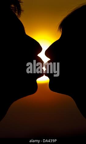 ILLUSTRATION - Une photo montre un homme et une femme s'embrasser devant le coucher du soleil à Francfort-sur-Oder, Allemagne, 02 juillet 2013. Les baisers jour est le 06 juillet 2013. Photo : Patrick Pleul Banque D'Images