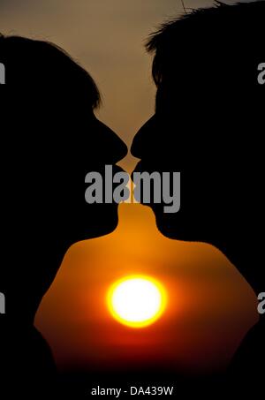 ILLUSTRATION - Une photo montre un homme et une femme s'embrasser devant le coucher du soleil à Francfort-sur-Oder, Allemagne, 02 juillet 2013. Les baisers jour est le 06 juillet 2013. Photo : Patrick Pleul Banque D'Images