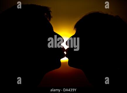 ILLUSTRATION - Une photo montre un homme et une femme s'embrasser devant le coucher du soleil à Francfort-sur-Oder, Allemagne, 02 juillet 2013. Les baisers jour est le 06 juillet 2013. Photo : Patrick Pleul Banque D'Images