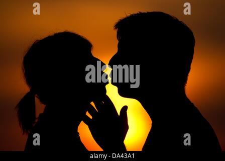 ILLUSTRATION - Une photo montre un homme et une femme s'embrasser devant le coucher du soleil à Francfort-sur-Oder, Allemagne, 02 juillet 2013. Les baisers jour est le 06 juillet 2013. Photo : Patrick Pleul Banque D'Images