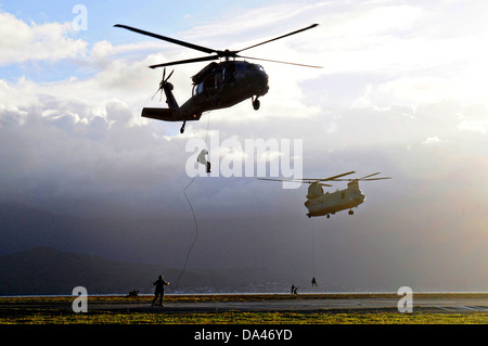 Les membres de l'équipe de l'US Navy SEAL rappel de la patrouille spéciale l'insertion et l'extraction corde attachée à un UH-60 Black Hawk et un hélicoptère CH-47F Chinook au cours de formation HELOCAST au Marine Corps Air Station Kaneohe Bay le 19 juin 2013 à Hawaii. Banque D'Images