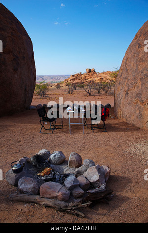 La cuisson du pain grillé sur un feu de camp au camping au Mowani Mountain Camp, près de Twyfelfontein, Damaraland, Namibie, Afrique Banque D'Images