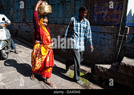 Femme transportant de l'eau sur la tête et marcher dans la rue. Jodhpur, Rajasthan, India Banque D'Images