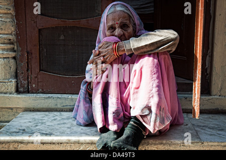 Portrait d'une femme âgée portant un sari rose et assis dans une porte. Jodhpur, Rajasthan, India Banque D'Images