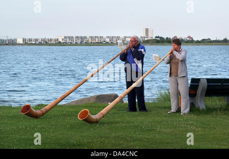 Ruth et Peter Zoller de la ville suisse de Genève jouer sur cors puisqu'elles se tiennent sur une plage de la mer Baltique près de Wulfen sur l'île de Fehmarn, Allemagne, 2 juillet 2013. Le couple est exerçant leurs talents pour une performance similaire dans la ville de nom de Behringen, située en Thuringe, où l'événement '5 x S(h)ringe(n) International' va avoir lieu du 12 juillet au 15 juillet, avec des représentants de cinq villes européennes au Luxembourg, Pays-Bas, Suisse, Belgique et Allemagne, portant le même nom de Behringen. Photo : Marcus Brandt Banque D'Images