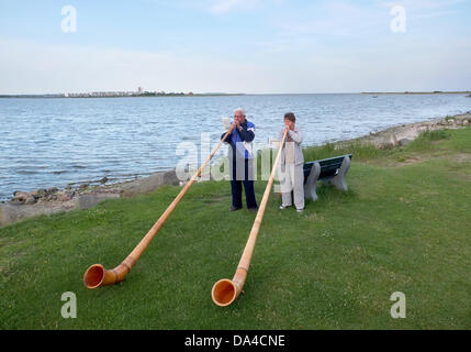 Ruth et Peter Zoller de la ville suisse de Genève jouer sur cors puisqu'elles se tiennent sur une plage de la mer Baltique près de Wulfen sur l'île de Fehmarn, Allemagne, 2 juillet 2013. Le couple est exerçant leurs talents pour une performance similaire dans la ville de nom de Behringen, située en Thuringe, où l'événement '5 x S(h)ringe(n) International' va avoir lieu du 12 juillet au 15 juillet, avec des représentants de cinq villes européennes au Luxembourg, Pays-Bas, Suisse, Belgique et Allemagne, portant le même nom de Behringen. Photo : Marcus Brandt Banque D'Images