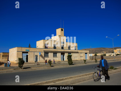 L'homme en passant en face d'une ancienne usine italienne coloniale, Dekemhare, Erythrée Banque D'Images