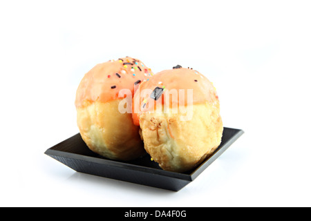 Les beignets à la crème d'Orange dans la lave noire. Banque D'Images