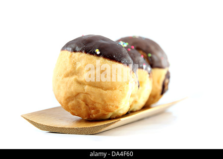 Beignes au chocolat dans le plat en bambou sur le fond blanc. Banque D'Images