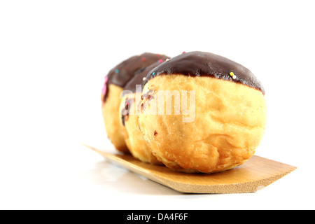 Beignes au chocolat dans le plat en bambou sur le fond blanc. Banque D'Images