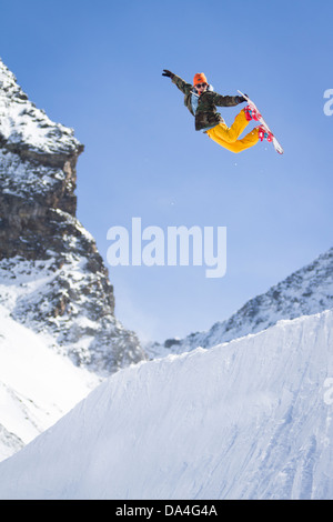 SAAS-fee, Valais, Suisse. Un planchiste exécute un tour d'air arrière sur un coin dans un snowpark freestyle. Banque D'Images