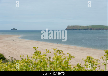 Personnes marchant sur une plage tranquille sur le fleuve de l'estuaire de Camel Padstow Cornwall UK à vers Daymer Bay et Polzeath Banque D'Images