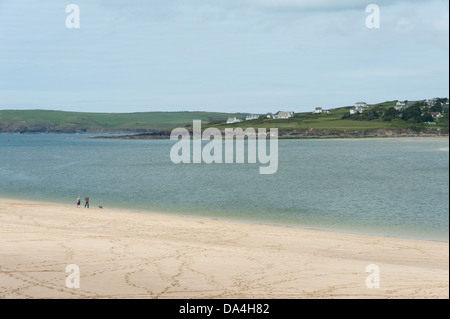 Personnes marchant sur une plage tranquille sur le fleuve de l'estuaire de Camel Padstow Cornwall UK à vers Daymer Bay et Polzeath Banque D'Images