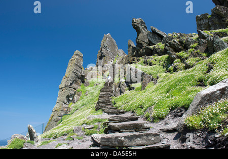 Un seul visiteur sur le derniers pas vers le haut de Skellig Michael ou Grand Skellig. Site de 6e à 8e siècle Monastère Banque D'Images