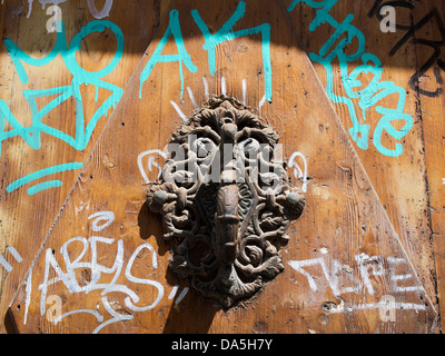 Graffitis et un marteau sur une porte dans le quartier gothique de Barcelone, Espagne Banque D'Images