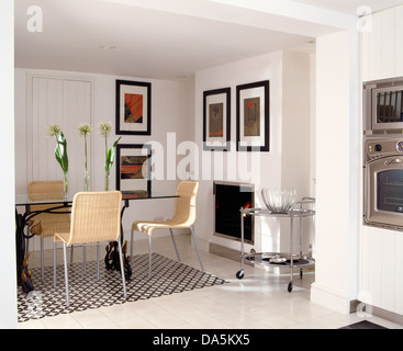 L'Osier +metal chaises table en verre dans cuisine moderne avec salle à manger noir +tapis blanc sur blanc marbre peint Banque D'Images