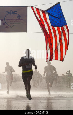 Un soldat de l'armée américaine franchit la ligne d'arrivée tout en participant à distance dans l'Atlanta Peachtree Road Race, une partie de la plus grande course de 10K le 4 juillet 2013 au Camp Sapadalure, province de Helmand, en Afghanistan. Banque D'Images