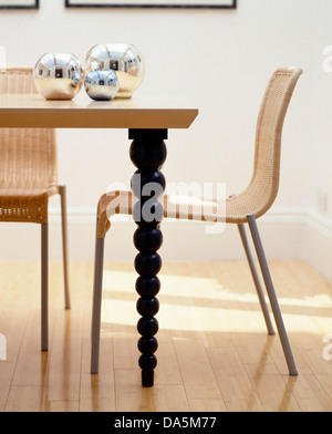 L'Osier +metal chaises table en bois avec fusée tourné les jambes dans la salle à manger moderne Banque D'Images