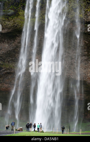 Les touristes en face de la cascade de Seljalandsfoss de la rivière Seljalandsá Islande Europe du sud de l'Océan Atlantique Banque D'Images