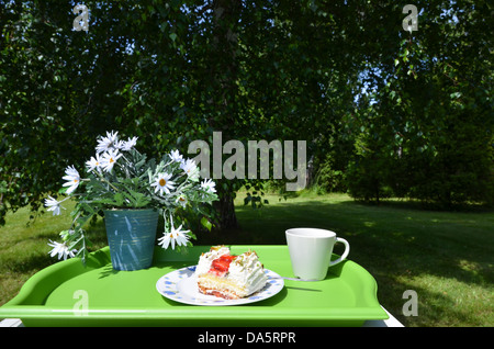 Table fait avec des fleurs, strawberry cake et une tasse pour le café Banque D'Images