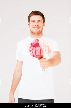 Jeune homme tenant un bouquet de fleurs Banque D'Images