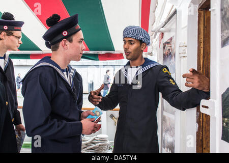 Aarhus, Danemark. 4 juillet, 2013. Membre d'équipage à la Marine royale d'Oman Shabab Oman navire, présentant le navire aux membres de l'équipage du navire danois Georg Stage, pendant la Tall Ships Races 2013 à Aarhus, Danemark. La ville d'Aarhus au Danemark, est le point de départ de cette années Tall Ships Races. L'événement comprend une flotte de 104 navires à voile et 3 000 membres d'équipage de tout le monde. Crédit : Michael Harder/Alamy Live News Banque D'Images