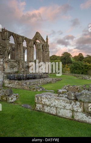 Vue de la lumière du soleil, l'ancienne et pittoresque de ruines monastiques Bolton Abbey dans belle campagne contre ciel coucher de soleil spectaculaire - Vallées du Yorkshire, England, UK. Banque D'Images