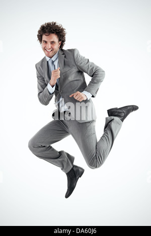 Jeune homme avec excitation saute en l'air en fête. Tir vertical. En regardant la caméra. Banque D'Images