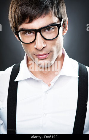 Un beau jeune homme portant des lunettes et des bretelles. Banque D'Images
