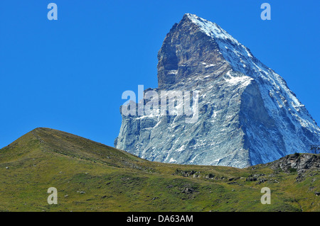 L'impressionnant et majestueux Matterhorn au-dessus de Zermatt dans les Alpes suisses, pris dans l'été avec des collines couvertes d'herbe dans le pour Banque D'Images