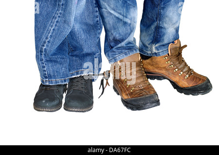 Deux paires de jambes, hommes et femmes en jeans bottes avec lacets attachés l'un à l'autre - l'amour pour toujours Banque D'Images