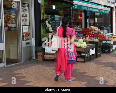 Morden London England Woman talking On Mobile Phone Shopping Walking Cours des légumes Banque D'Images