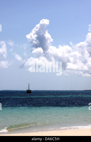 Un dhow traditionnel bateau à voile sur l'eau bleu émeraude le long d'une plage de sable blanc à Zanzibar Banque D'Images