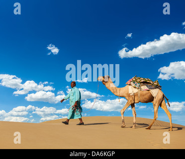 Arrière-plan de voyage Rajasthan - Indian chamelier (chamelier) avec des chameaux dans les dunes du désert du Thar. Udaipur, Rajasthan, Inde Banque D'Images